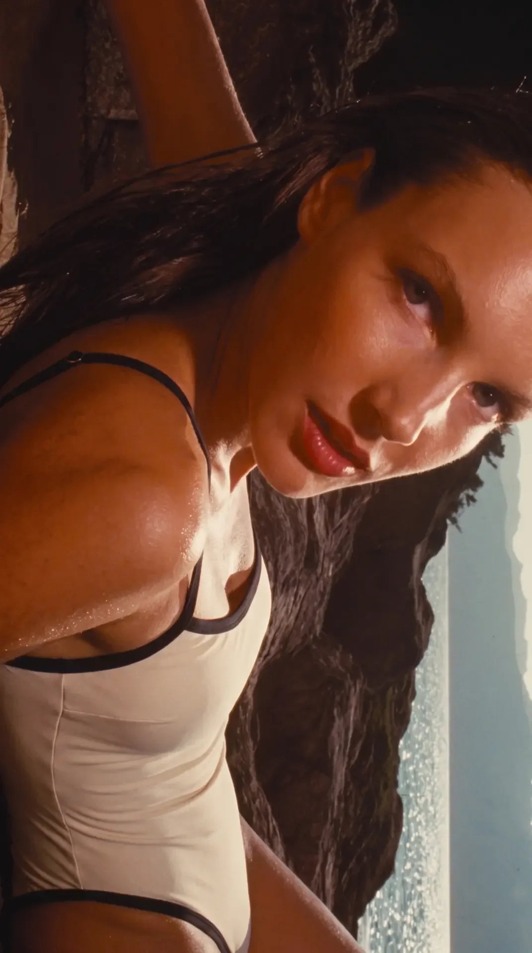 BLOND ivory swimsuit with black trim in warm coastal light